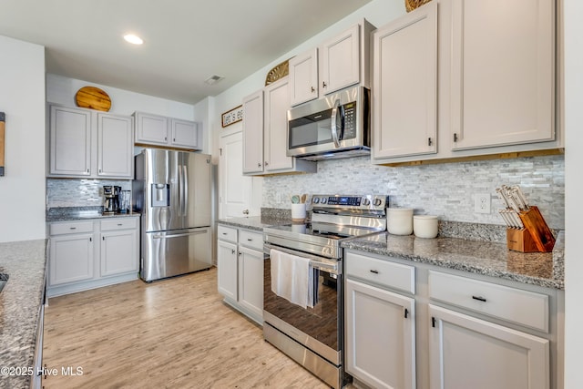 815 Avington Ln NE, Leland, NC 28451 - kitchen with appliances with stainless steel finishes, backsplash, light wood-style flooring, and light stone countertops