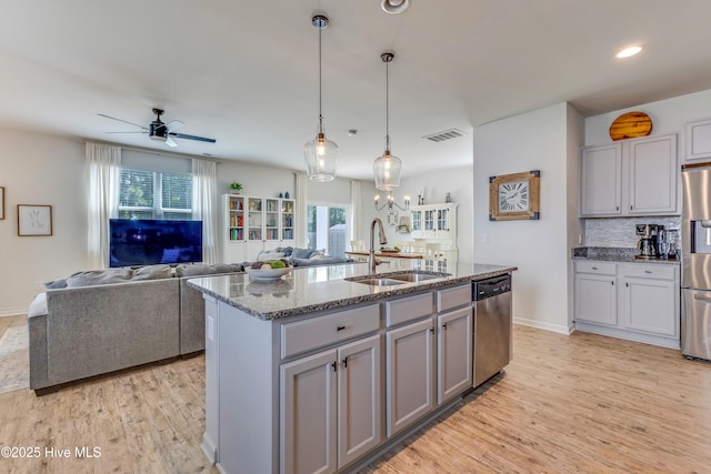 815 Avington Ln NE, Leland, NC 28451 - kitchen with a sink, appliances with stainless steel finishes, gray cabinetry, dark stone countertops, and light wood-style floors
