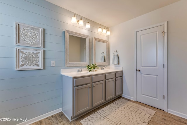 815 Avington Ln NE, Leland, NC 28451 - bathroom featuring wood finished floors, double vanity, baseboards, and wooden walls