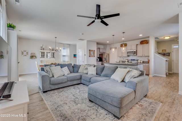 815 Avington Ln NE, Leland, NC 28451 - living room with a chandelier, light wood-style floors, a ceiling fan, baseboards, and recessed lighting