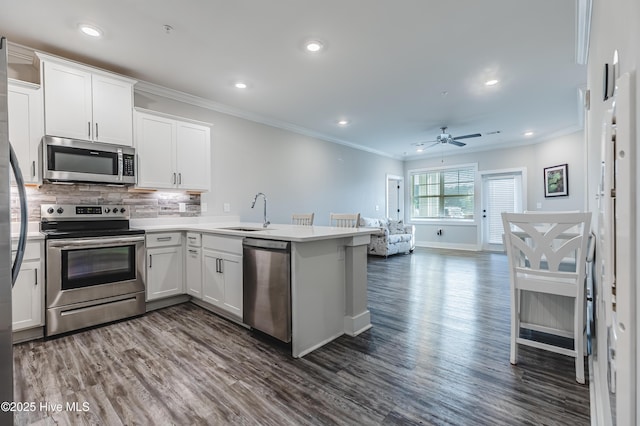 395 S Crow Creek Dr Unit 1601, Calabash, NC 28467 - kitchen featuring appliances with stainless steel finishes, a sink, a peninsula, white cabinets, and tasteful backsplash
