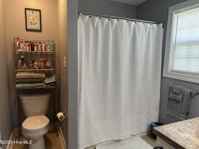 full bath featuring toilet, tile patterned flooring, and a shower with curtain