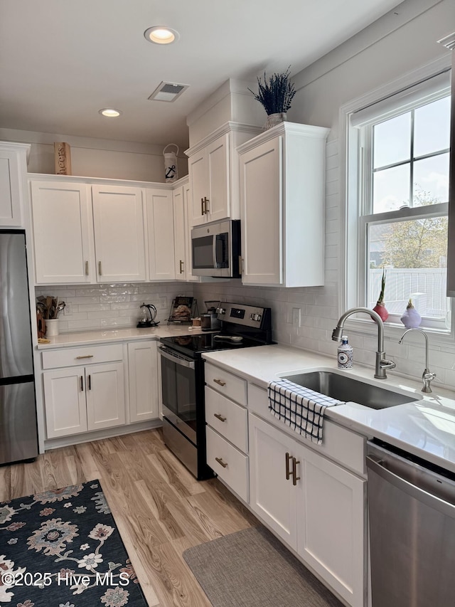 264 Great Egret Way, Beaufort, NC 28516 - kitchen with stainless steel appliances, a sink, tasteful backsplash, white cabinetry, and recessed lighting