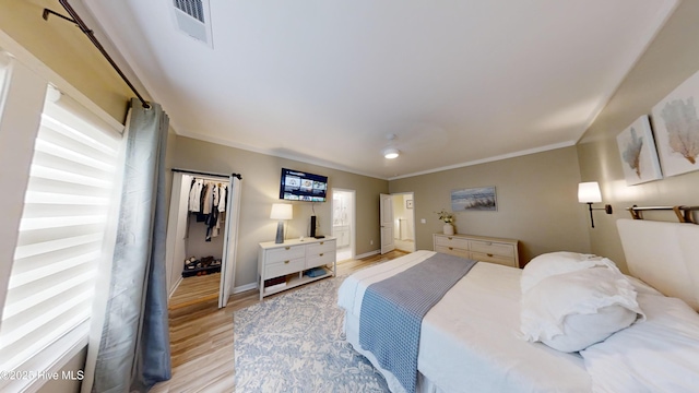264 Great Egret Way, Beaufort, NC 28516 - bedroom with light wood finished floors, ornamental molding, baseboards, and a barn door