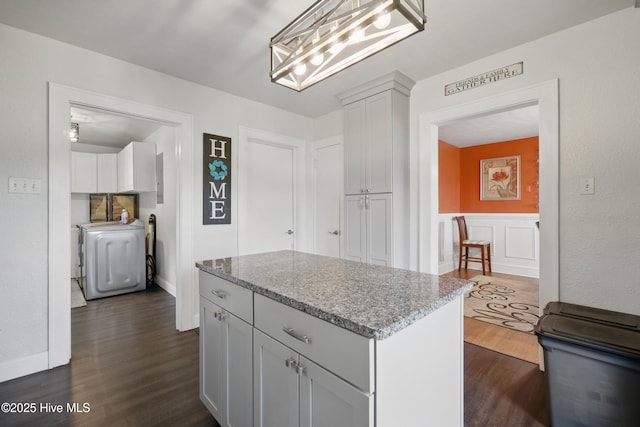 1047 US Highway 158 W, Gates, NC 27937 - kitchen with washer / dryer, dark wood-type flooring, a kitchen island, light stone counters, and a wainscoted wall