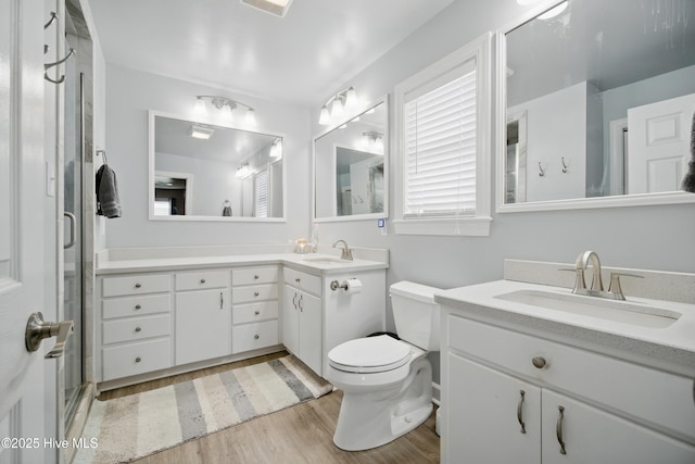 1047 US Highway 158 W, Gates, NC 27937 - bathroom featuring wood finished floors, a stall shower, two vanities, and toilet