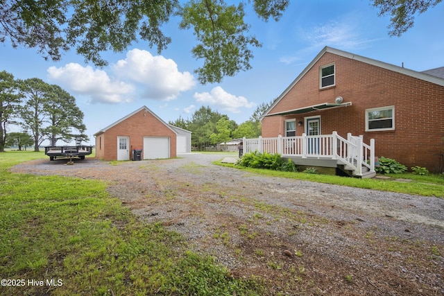 1047 US Highway 158 W, Gates, NC 27937 - view of home's exterior with brick siding, a garage, an outdoor structure, and a wooden deck
