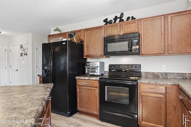 112 Silver Queen Ln, Richlands, NC 28574 - kitchen with black appliances, light wood-style floors, and brown cabinets