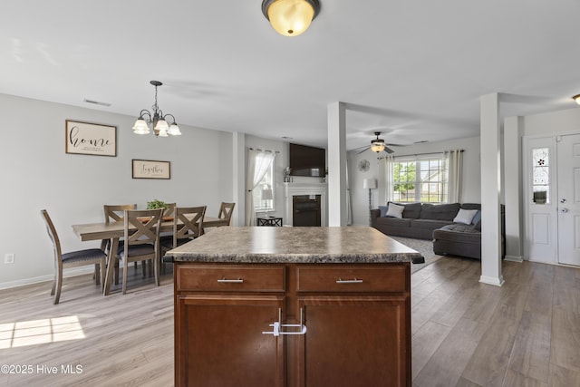 112 Silver Queen Ln, Richlands, NC 28574 - kitchen featuring light wood finished floors, a fireplace, ceiling fan, and dark countertops