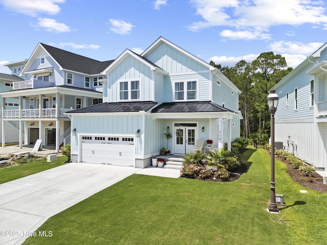 510 White Picket Way, Holly Ridge, NC 28445 - view of front facade featuring board and batten siding, a standing seam roof, concrete driveway, a front lawn, and an attached garage