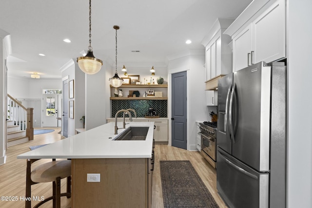 510 White Picket Way, Holly Ridge, NC 28445 - kitchen with stainless steel appliances, a sink, light wood-style flooring, an island with sink, and light countertops