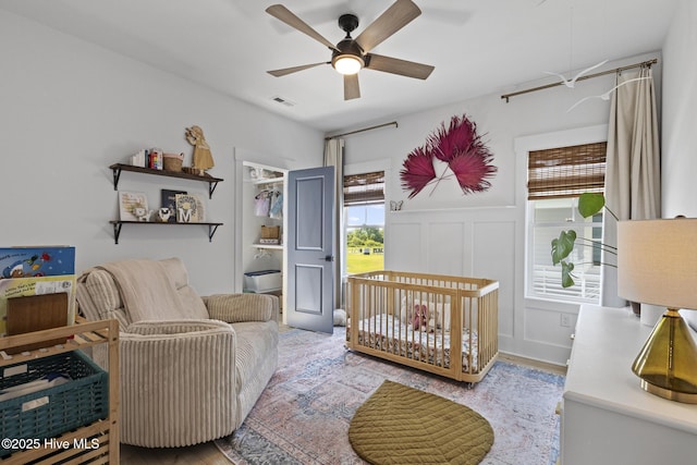 510 White Picket Way, Holly Ridge, NC 28445 - bedroom featuring wood finished floors, a decorative wall, ceiling fan, and a wainscoted wall
