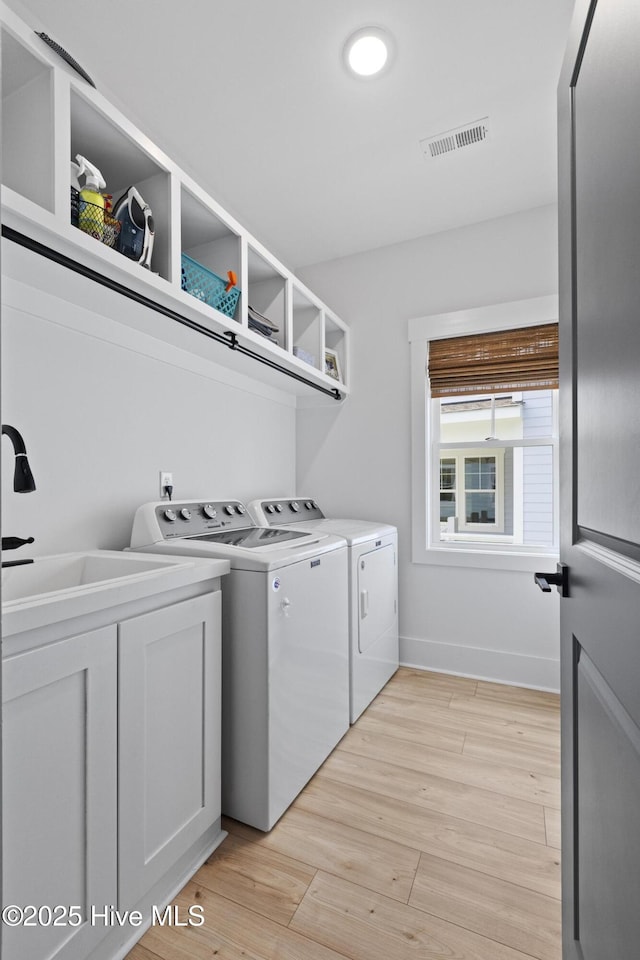 510 White Picket Way, Holly Ridge, NC 28445 - laundry room featuring washing machine and clothes dryer, light wood-type flooring, cabinet space, and baseboards