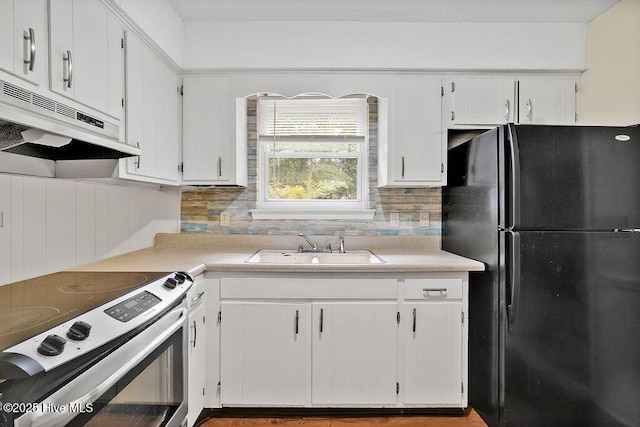 326 Spartan Rd, Wilmington, NC 28405 - kitchen featuring freestanding refrigerator, stainless steel range with electric cooktop, a sink, under cabinet range hood, and white cabinets