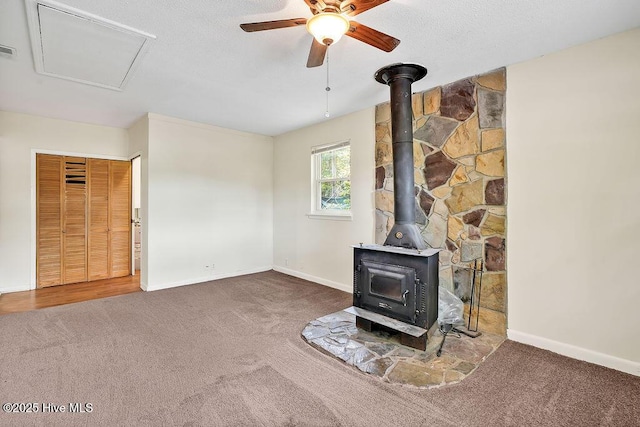 326 Spartan Rd, Wilmington, NC 28405 - unfurnished living room with carpet, a wood stove, ceiling fan, and baseboards