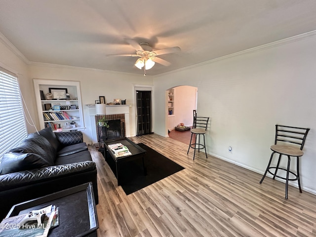 303 S Andrews Ave, Goldsboro, NC 27530 - living area featuring ornamental molding, wood finished floors, arched walkways, a ceiling fan, and a fireplace