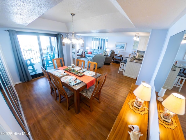1505 Salter Path Rd Unit 319, Indian Beach, NC 28512 - dining area featuring a chandelier, wood finished floors, a textured ceiling, and baseboards