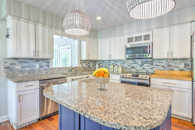 2428 Tram Rd, New Bern, NC 28562 - kitchen with stainless steel appliances, white cabinets, a sink, recessed lighting, and a kitchen island