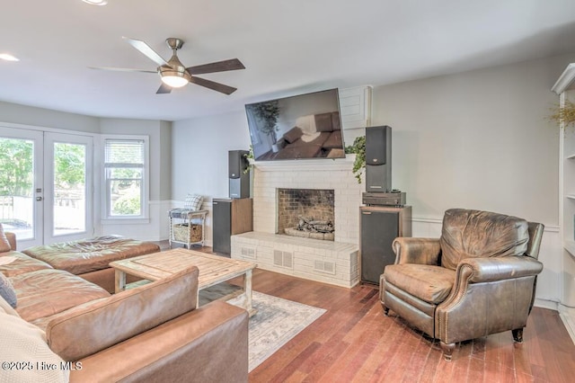 2428 Tram Rd, New Bern, NC 28562 - living area with ceiling fan, wainscoting, wood finished floors, a brick fireplace, and french doors