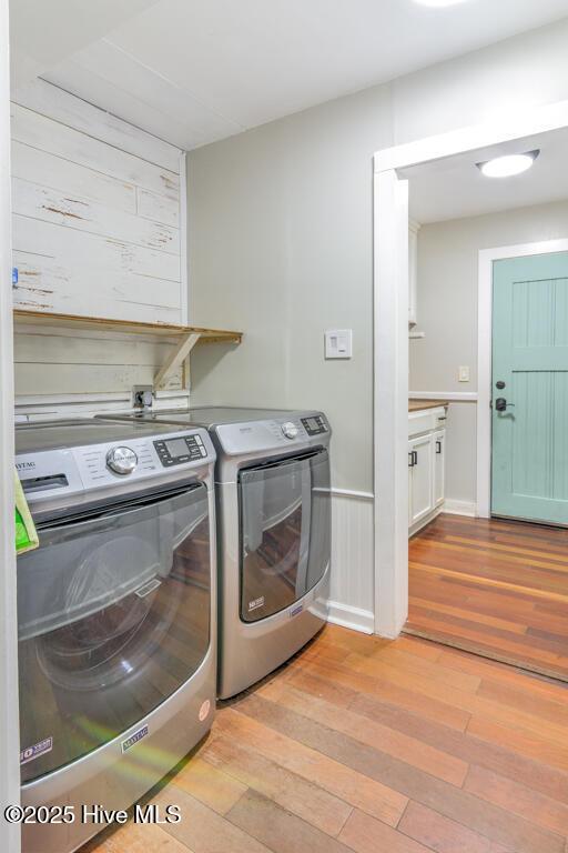 2428 Tram Rd, New Bern, NC 28562 - laundry room with light wood-style flooring, separate washer and dryer, and wooden walls