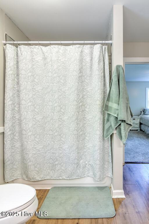 2428 Tram Rd, New Bern, NC 28562 - full bath with wood finished floors, toilet, and a shower with curtain