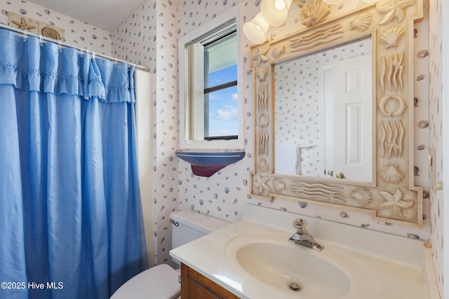1008 Canal Dr Unit 3A, Carolina Beach, NC 28428 - bathroom with wallpapered walls, toilet, vanity, and a shower with shower curtain