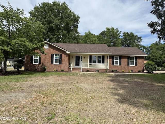 ranch-style house featuring crawl space, covered porch, brick siding, and a front lawn