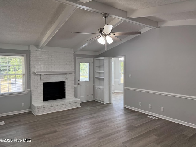 unfurnished living room with a textured ceiling, ceiling fan, wood finished floors, a fireplace, and baseboards