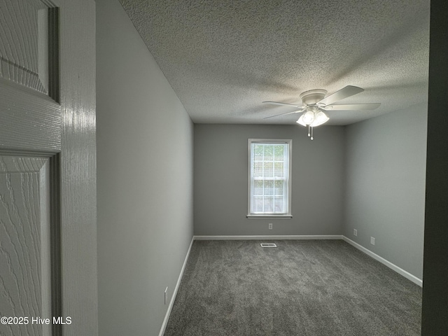 carpeted spare room with a ceiling fan, baseboards, and a textured ceiling