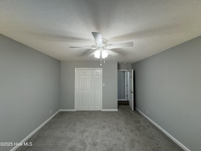 unfurnished bedroom with baseboards, carpet, a closet, a textured ceiling, and a ceiling fan