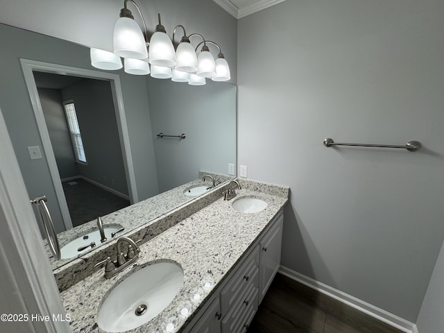full bath with baseboards, double vanity, crown molding, and wood finished floors