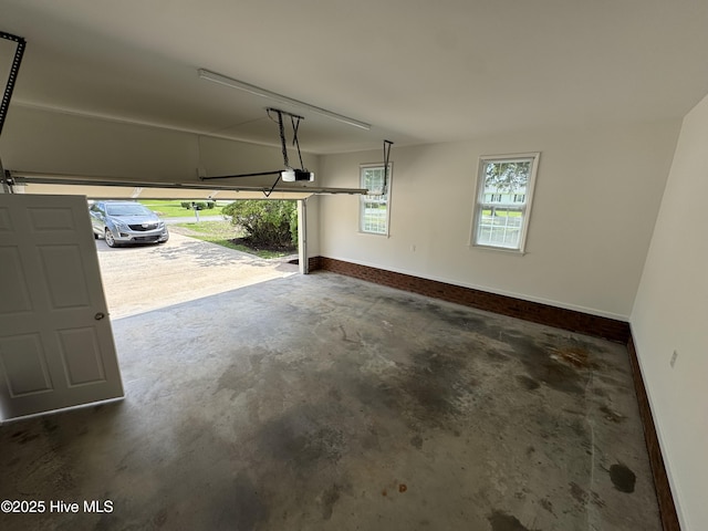 garage with a garage door opener and baseboards
