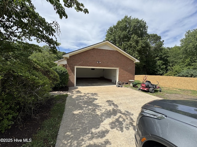 view of side of property featuring brick siding, concrete driveway, and a garage
