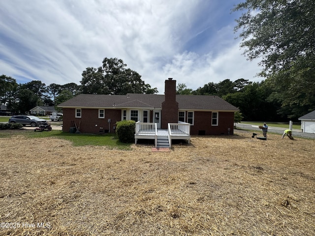 back of house with a chimney, a deck, brick siding, a yard, and crawl space
