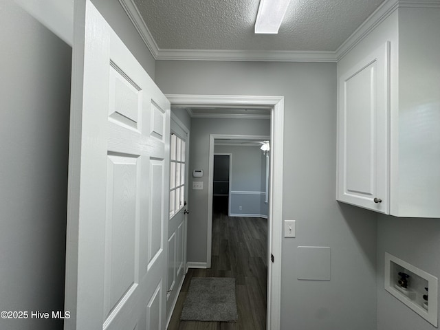 laundry room with cabinet space, washer hookup, dark wood finished floors, a textured ceiling, and ornamental molding