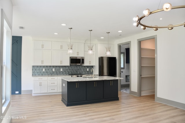 120 Fairview Rd, Leland, NC 28451 - kitchen featuring stainless steel microwave, fridge, a sink, white cabinetry, and tasteful backsplash