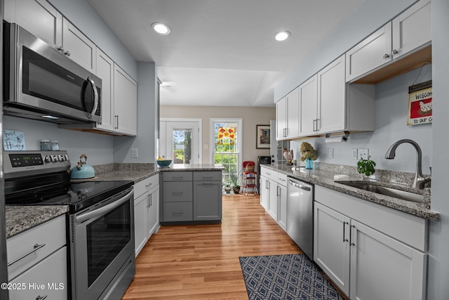 6008 Cassowary Ln, New Bern, NC 28560 - kitchen featuring stainless steel appliances, a sink, light wood-style floors, recessed lighting, and light stone countertops