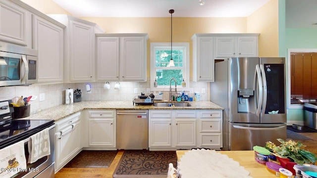 44 Nassau Ct, Clayton, NC 27520 - kitchen with stainless steel appliances, a sink, white cabinetry, and light stone countertops