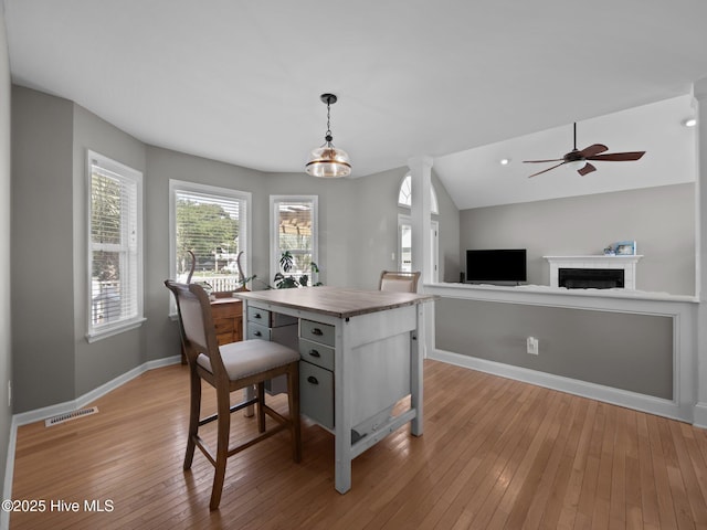 120 Buds Ln, Cedar Point, NC 28584 - kitchen with baseboards, light wood finished floors, hanging light fixtures, a ceiling fan, and a fireplace