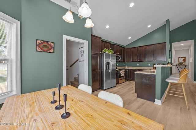 211 Bill Canady Rd, Sneads Ferry, NC 28460 - kitchen featuring appliances with stainless steel finishes, dark brown cabinetry, light wood-style flooring, a breakfast bar area, and pendant lighting
