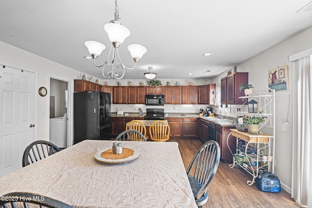 531 S NC Highway 343, Camden, NC 27921 - kitchen with black appliances, wood finished floors, a chandelier, pendant lighting, and light countertops