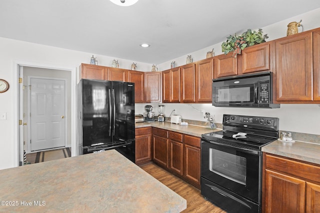 531 S NC Highway 343, Camden, NC 27921 - kitchen with black appliances, wood finished floors, light countertops, recessed lighting, and brown cabinets