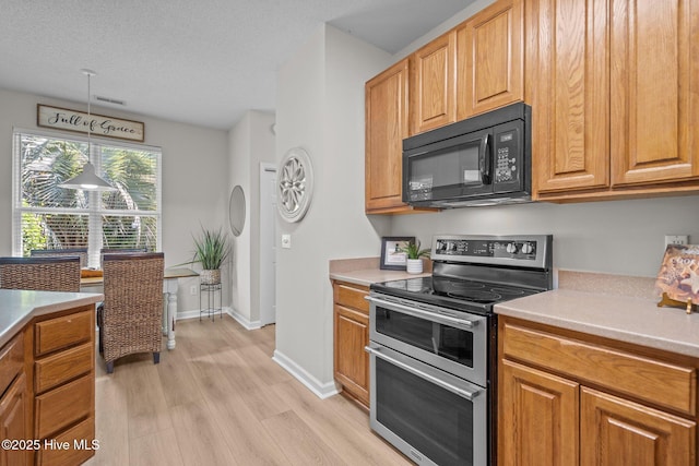 1424 Elgin St, Wilmington, NC 28409 - kitchen with black microwave, range with two ovens, light wood-style flooring, and light countertops