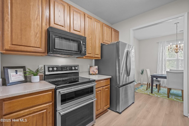 1424 Elgin St, Wilmington, NC 28409 - kitchen featuring appliances with stainless steel finishes, light wood finished floors, a chandelier, and light countertops