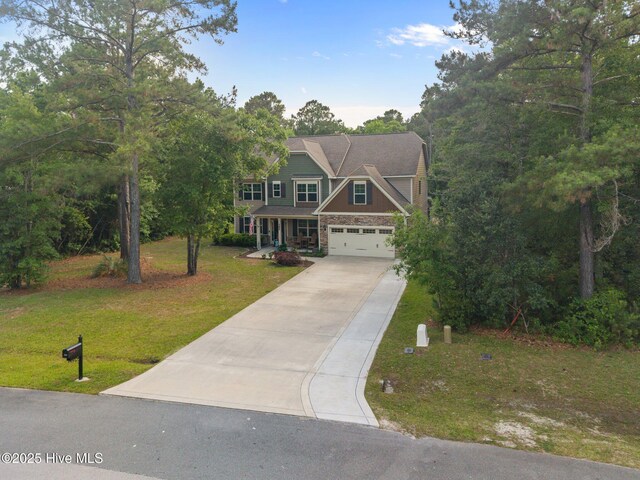 285 Mimosa Dr, Sneads Ferry, NC 28460 - view of front of home with concrete driveway, a front yard, stone siding, and a garage