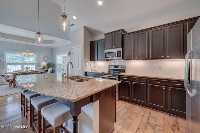 6122 Chancellorsville Dr, Wilmington, NC 28409 - kitchen with stainless steel appliances, a sink, a breakfast bar area, light wood-style floors, and recessed lighting