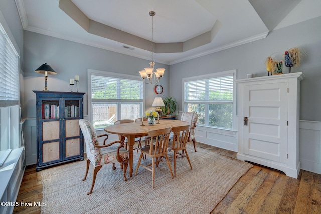 6122 Chancellorsville Dr, Wilmington, NC 28409 - dining area with wood finished floors, healthy amount of natural light, a chandelier, crown molding, and a wainscoted wall