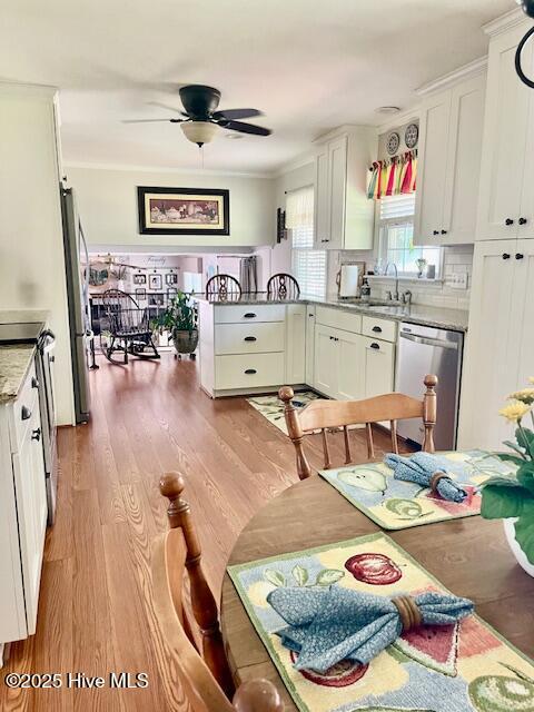 2008 Hardee Rd, Kinston, NC 28504 - kitchen featuring stainless steel appliances, a sink, a ceiling fan, white cabinets, and light wood-style flooring