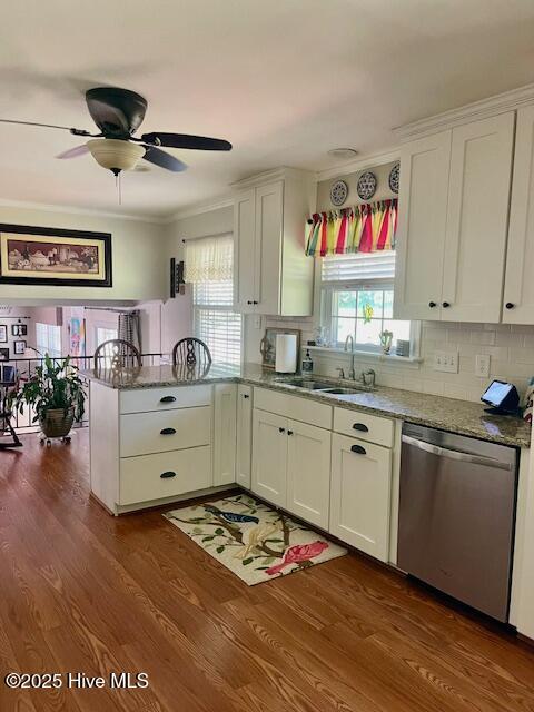 2008 Hardee Rd, Kinston, NC 28504 - kitchen with stainless steel dishwasher, a sink, a peninsula, white cabinetry, and ornamental molding