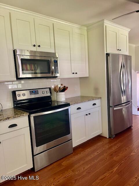 2008 Hardee Rd, Kinston, NC 28504 - kitchen with appliances with stainless steel finishes, light stone countertops, decorative backsplash, dark wood finished floors, and white cabinetry